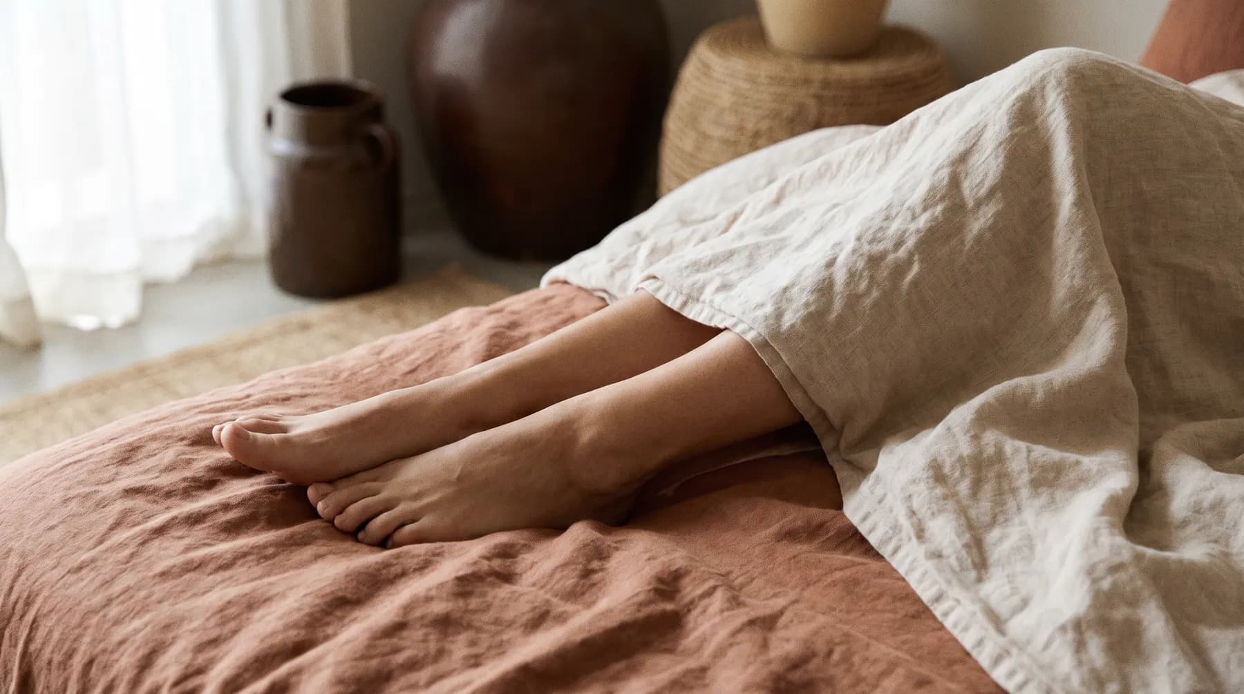Jambes au repos sur un drap de lin