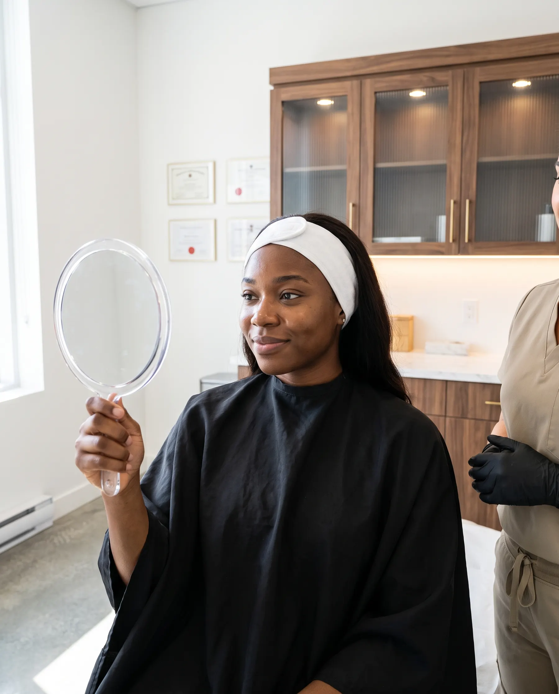 The client looking at herself in the mirror, smiling