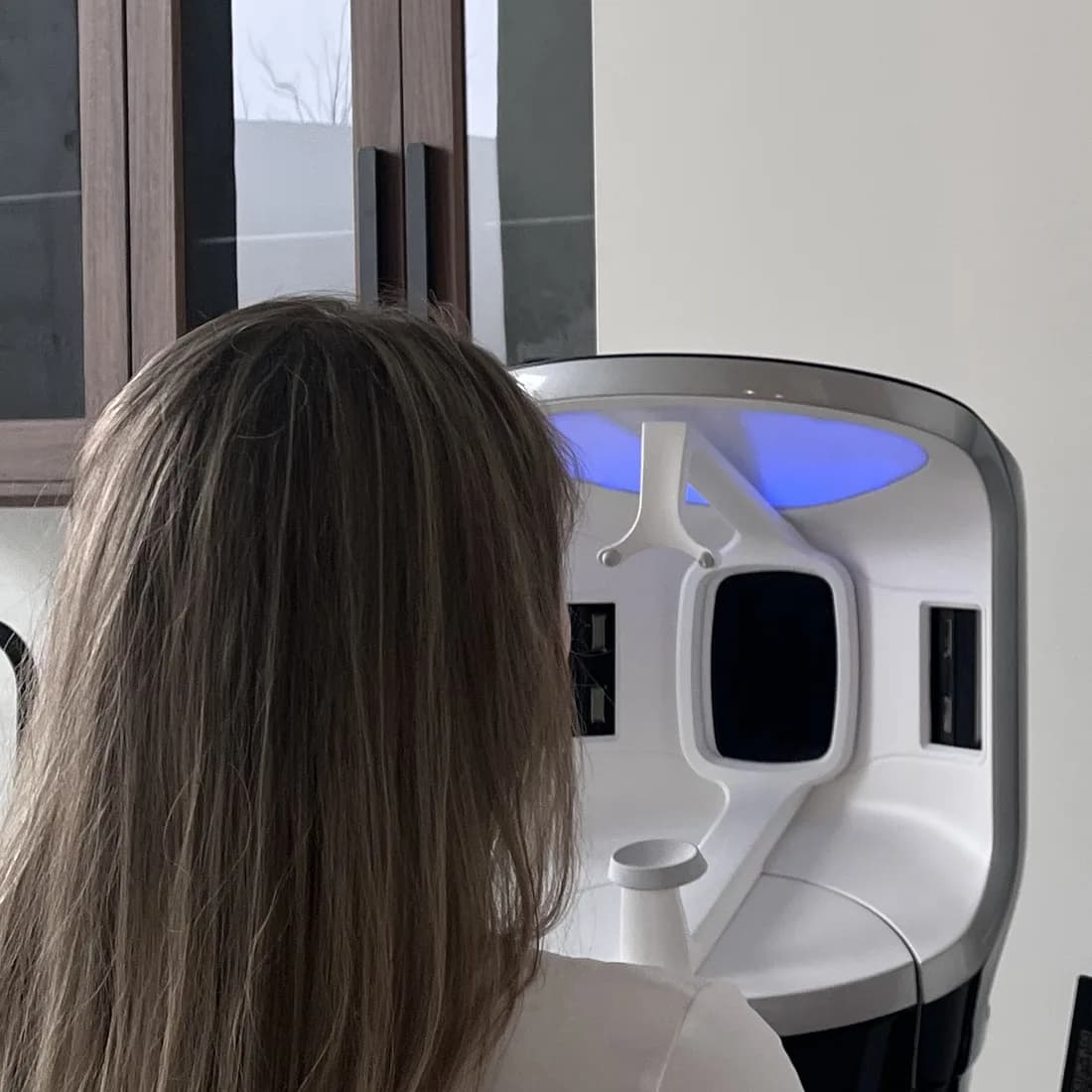 A client seated in front of the Visia device, before her skin analysis