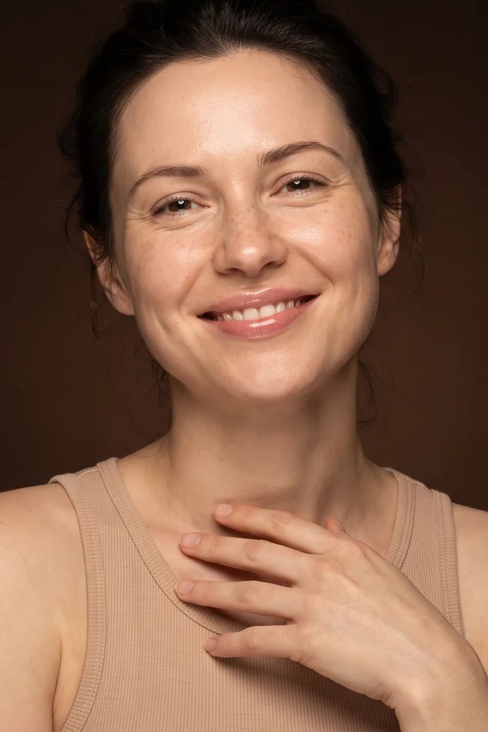 A smiling woman, hand on her collarbone