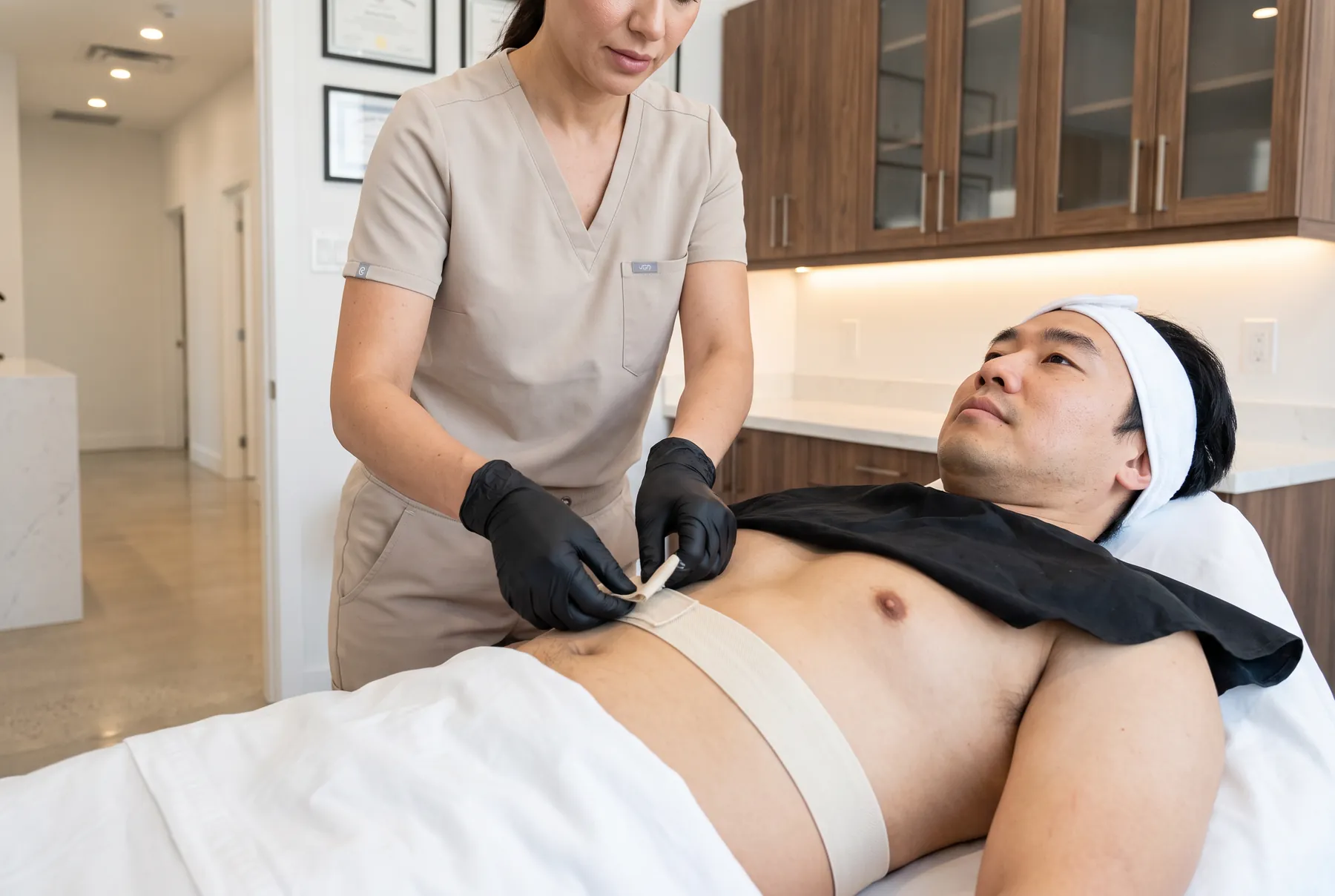 Sangle d'électrodes posée sur l'abdomen d'un homme allongé
