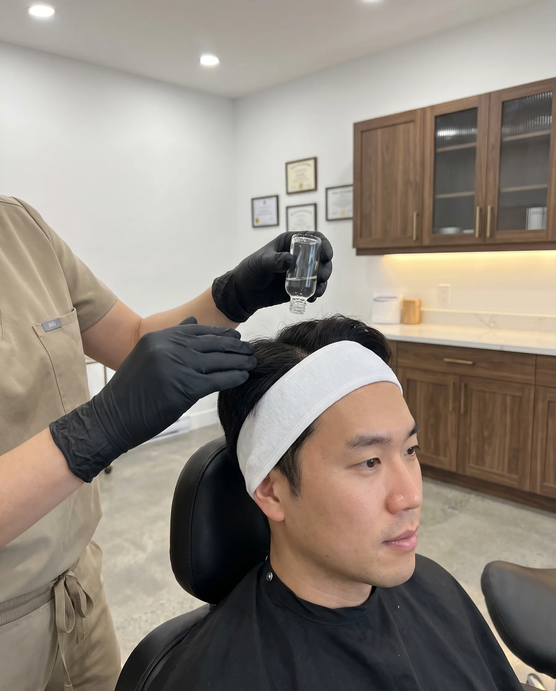 A solution applied along the parting on a man's scalp