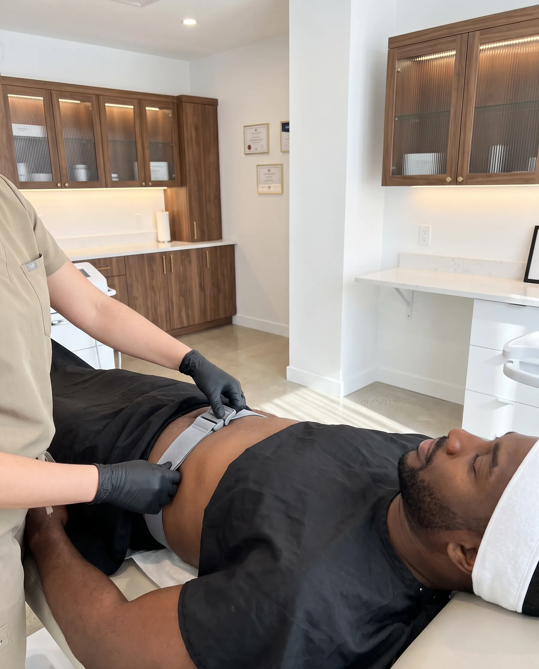 An electrode strap being fastened across a man's abdomen