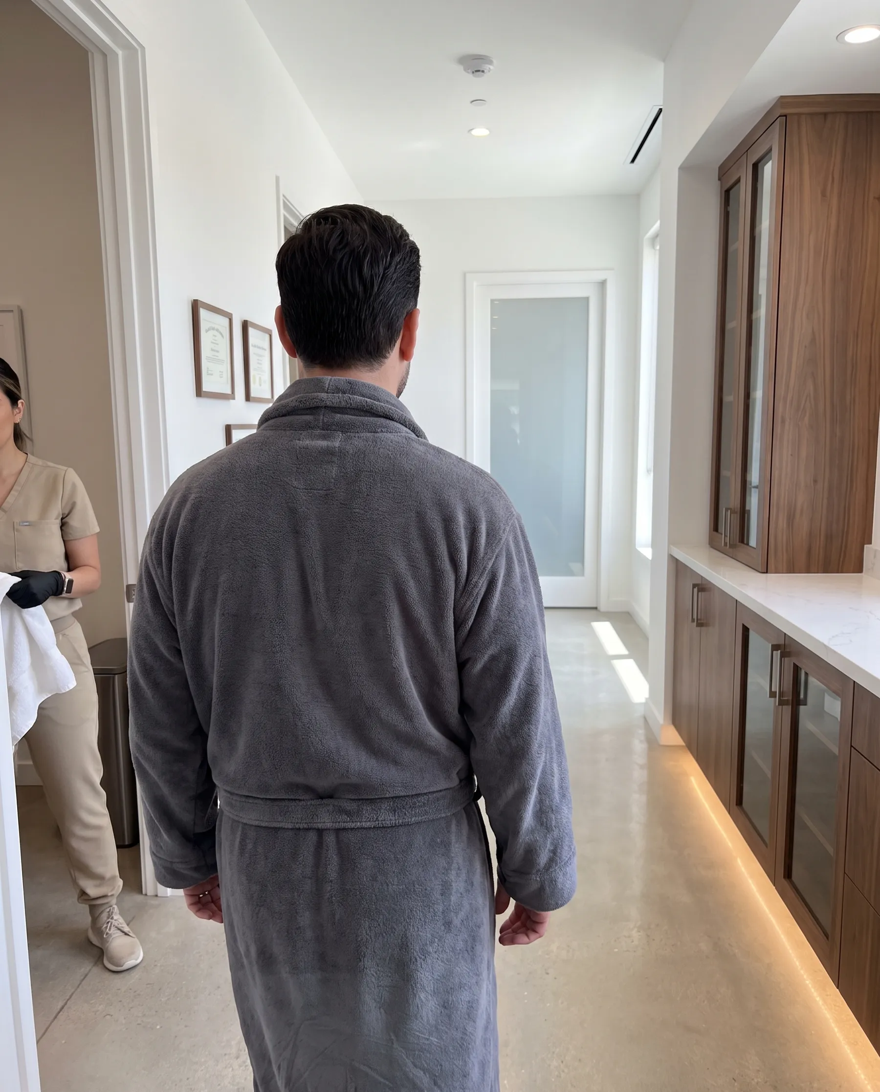 A man in a robe walking toward the showers