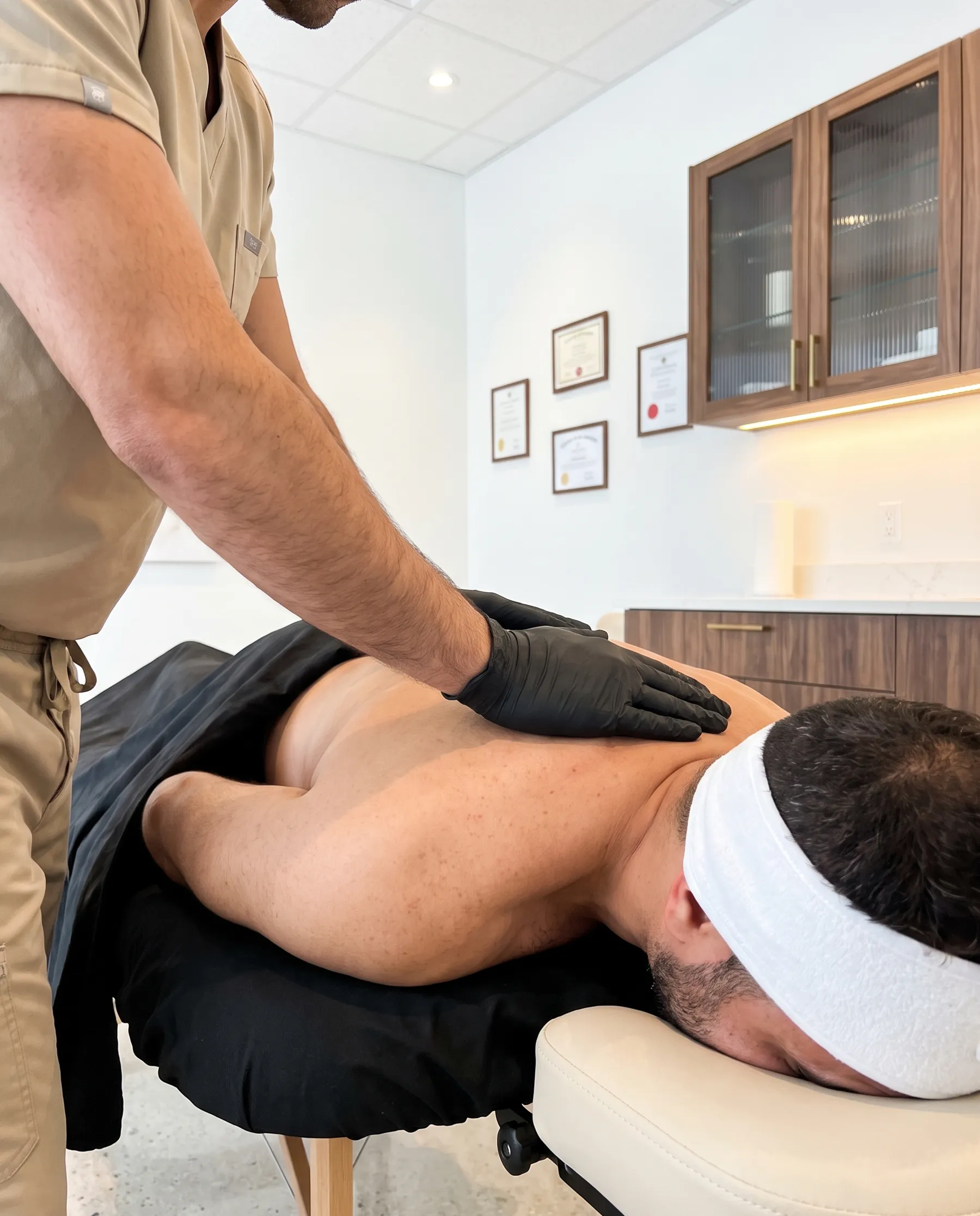 A forearm working deep along a man's upper back