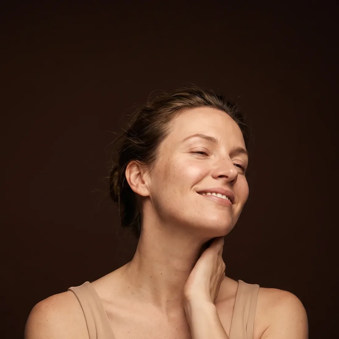 Woman with her head tilted slightly back, eyes half closed, soothed smile