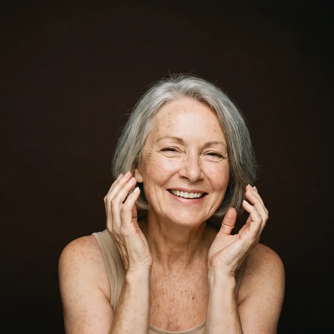 Woman in her sixties, smiling, hands open near her face