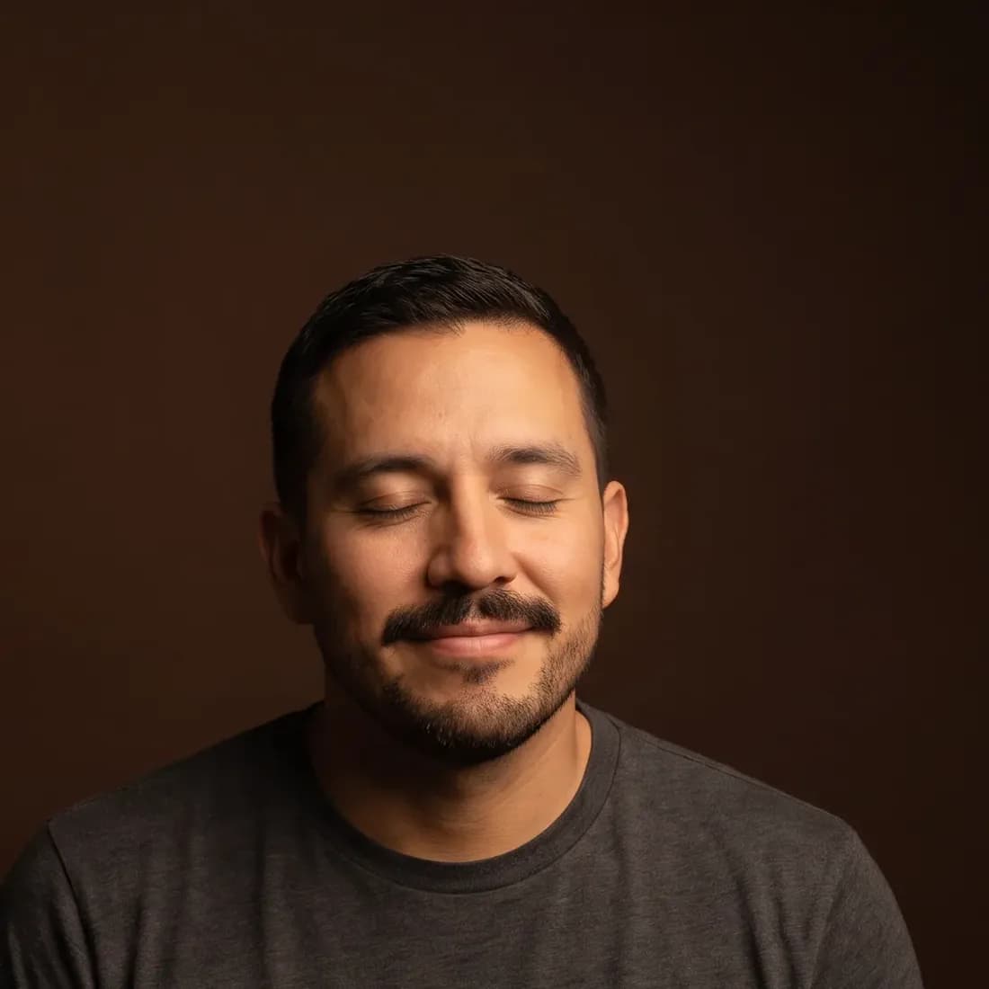 A man of about thirty-eight with a moustache and short beard, eyes half closed