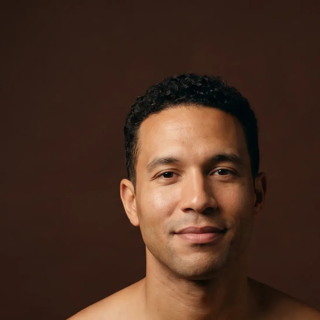 A man of about thirty-six with curly hair, bare shoulders
