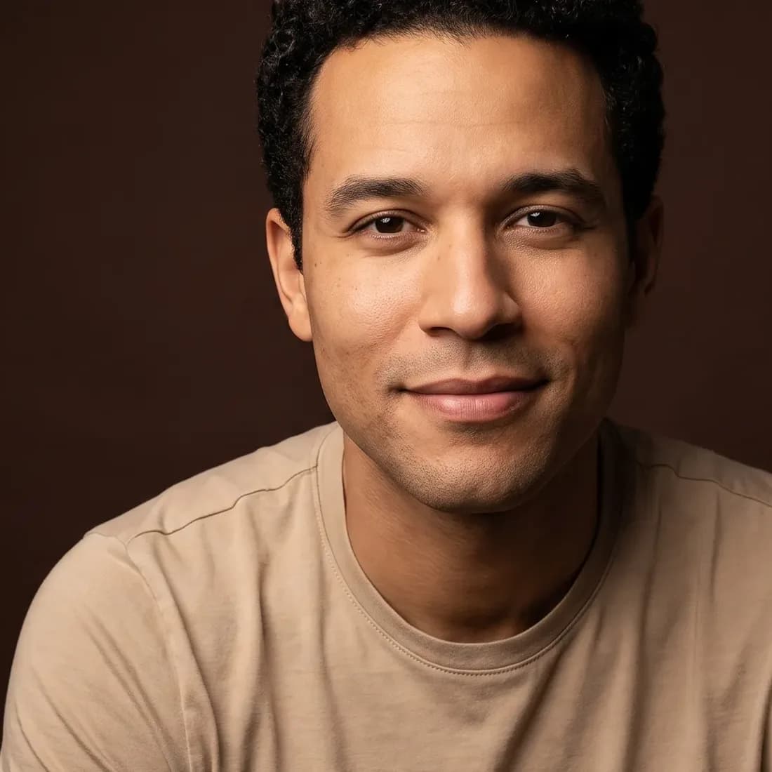 A man of about thirty-five with tight curls, clean-shaven