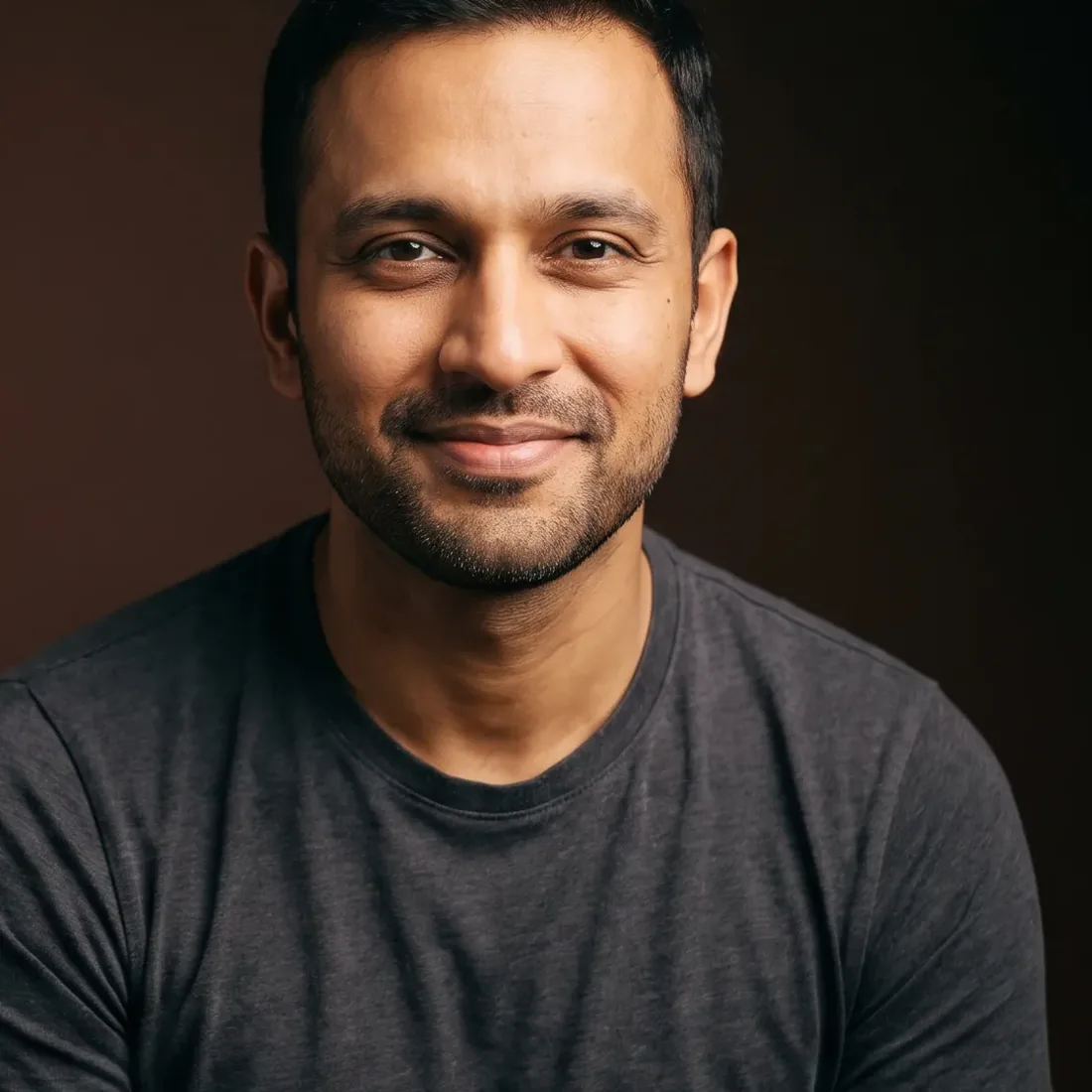 A man of about thirty-six with black hair and neat stubble