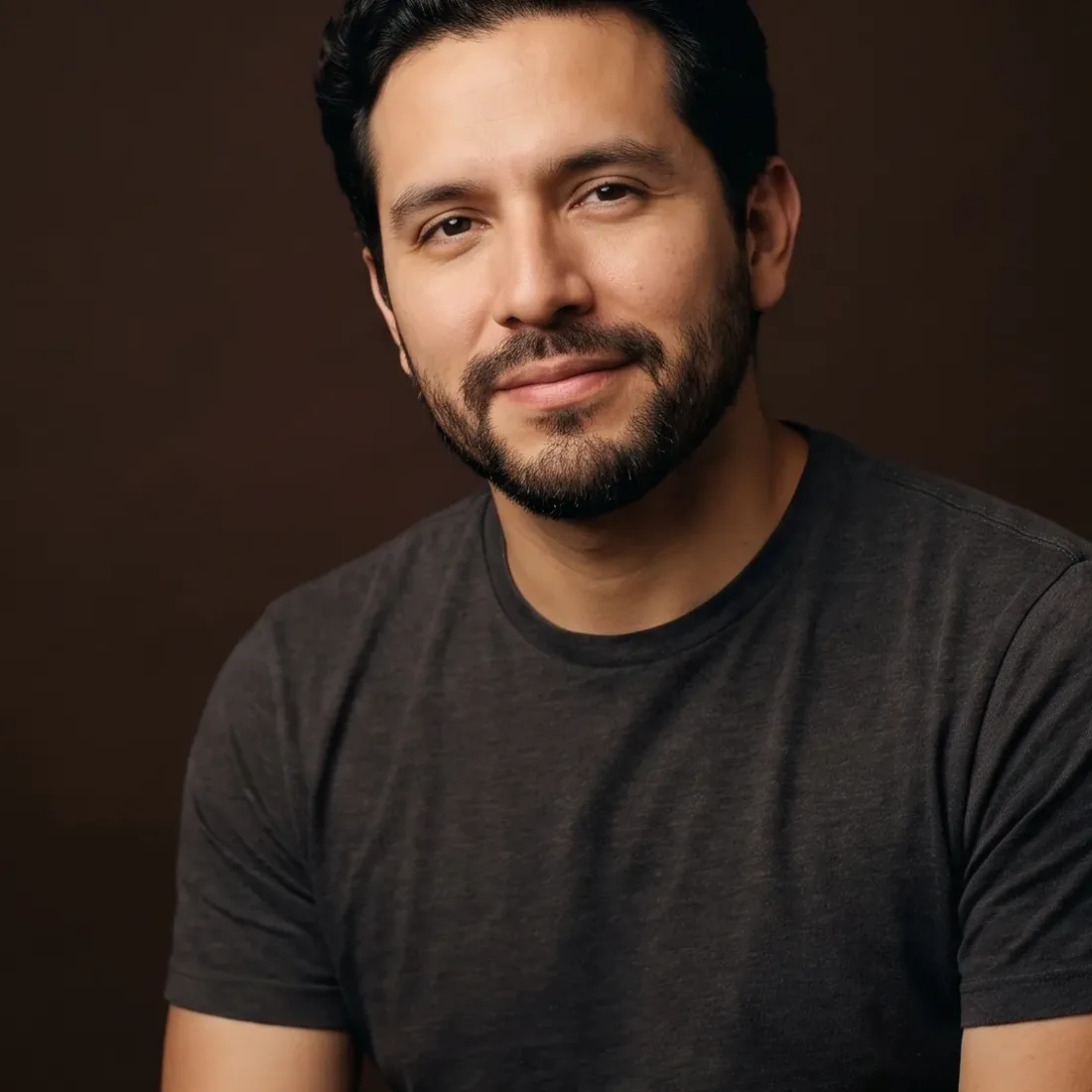 A man of about thirty-five with wavy hair and a trimmed beard