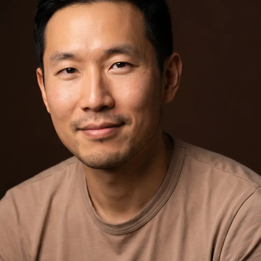 A man of about thirty-eight with short black hair and light stubble