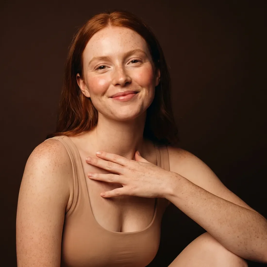Young red-haired woman, freckles clearly visible, gentle smile