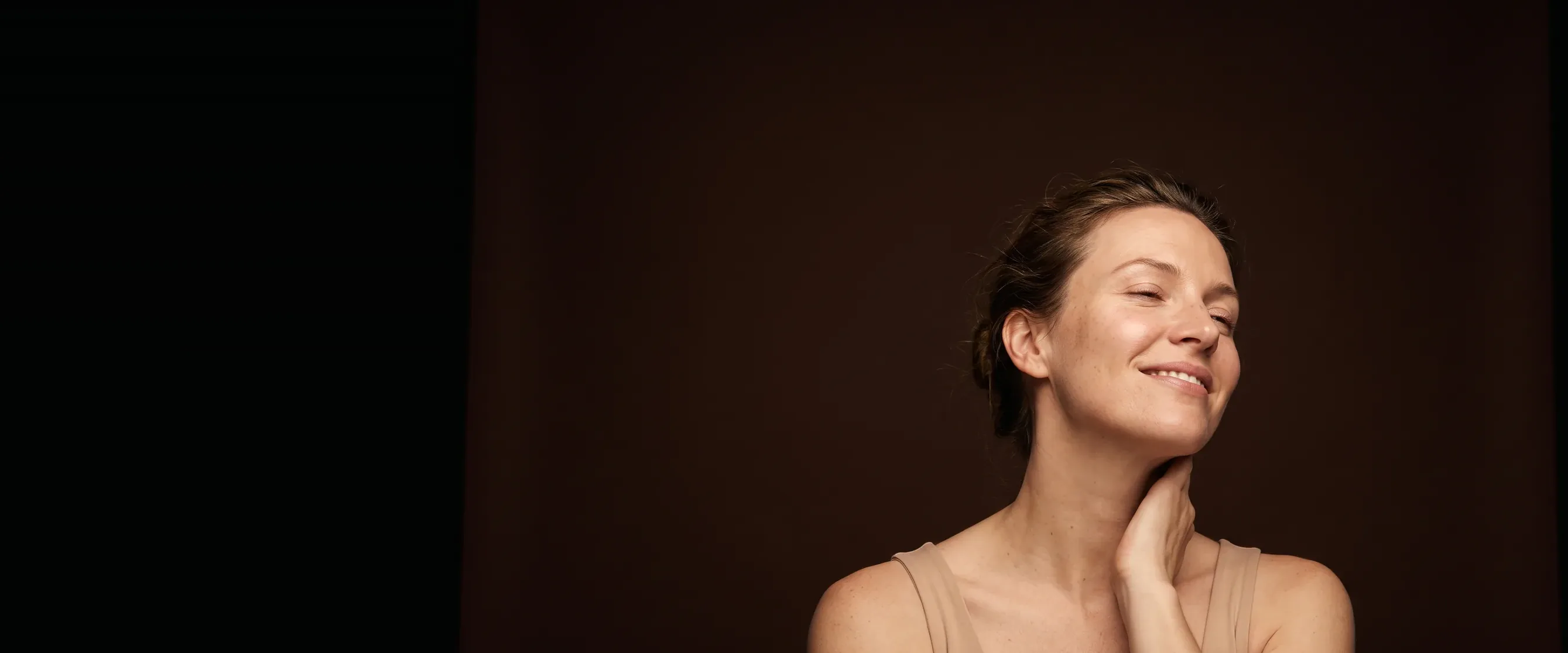 Femme assise, tête légèrement inclinée, sourire posé