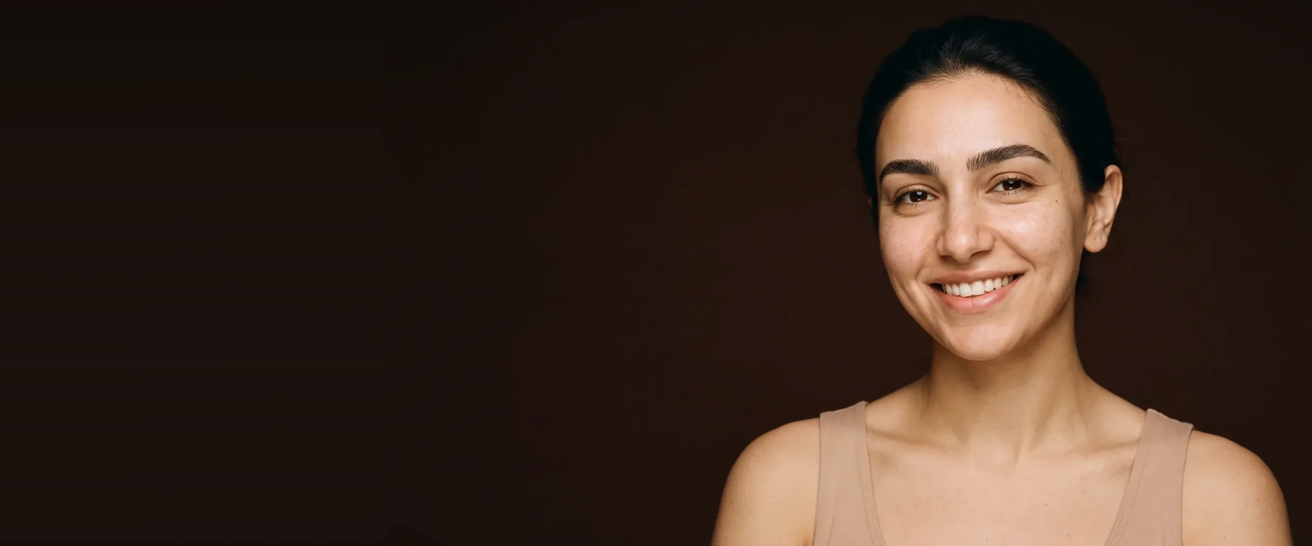 A smiling woman, bare face, brows naturally shaped