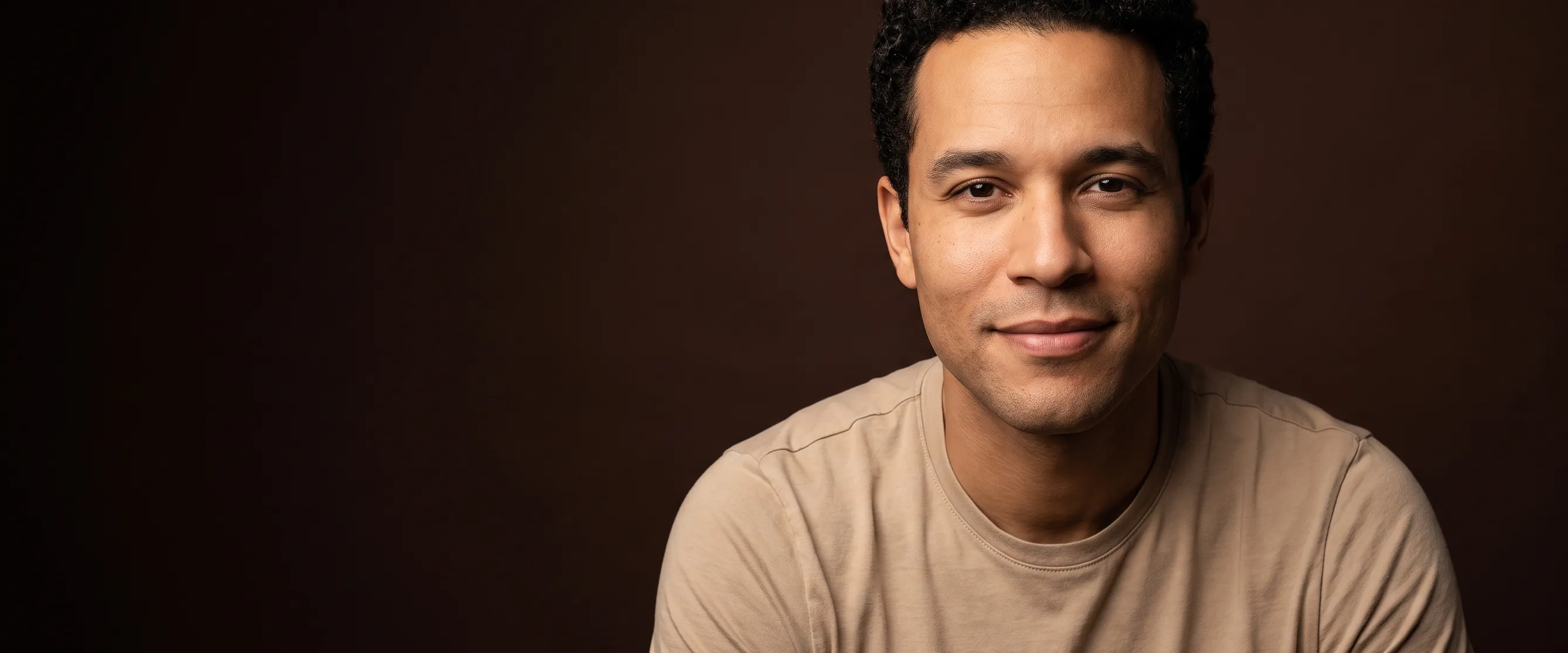 A man of about thirty-five with tight curls, clean-shaven