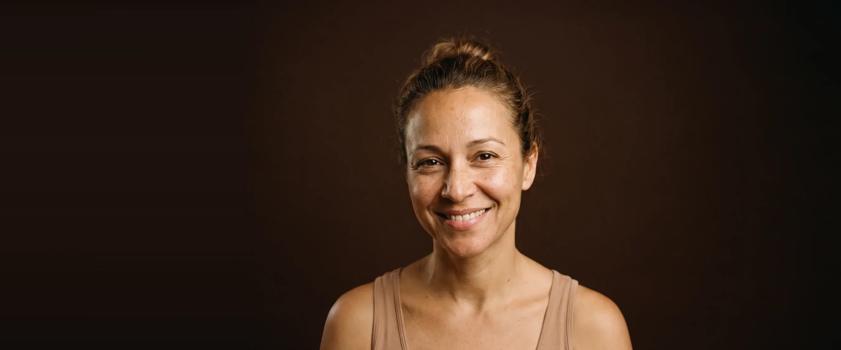 A woman with clear eyes, the eye area rested, smiling warmly