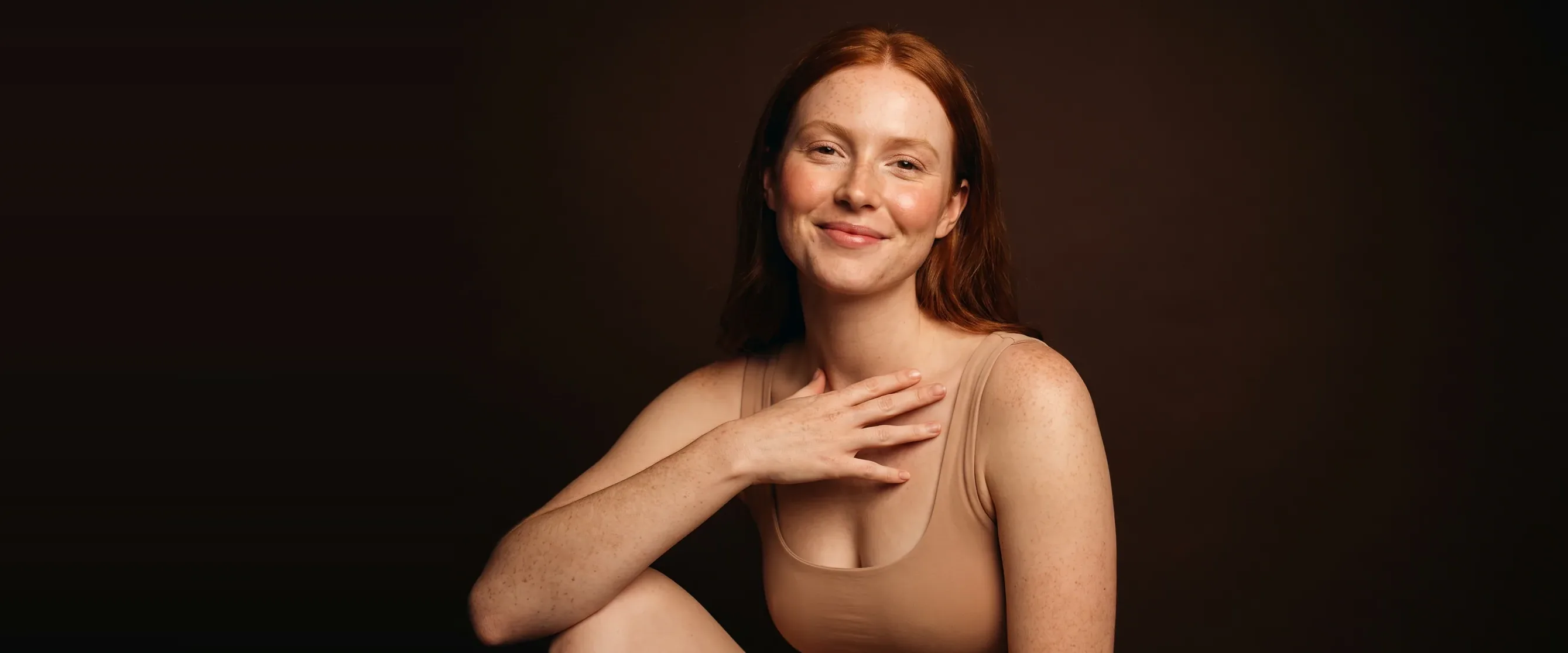 A young redhead with clear freckles, a soft smile
